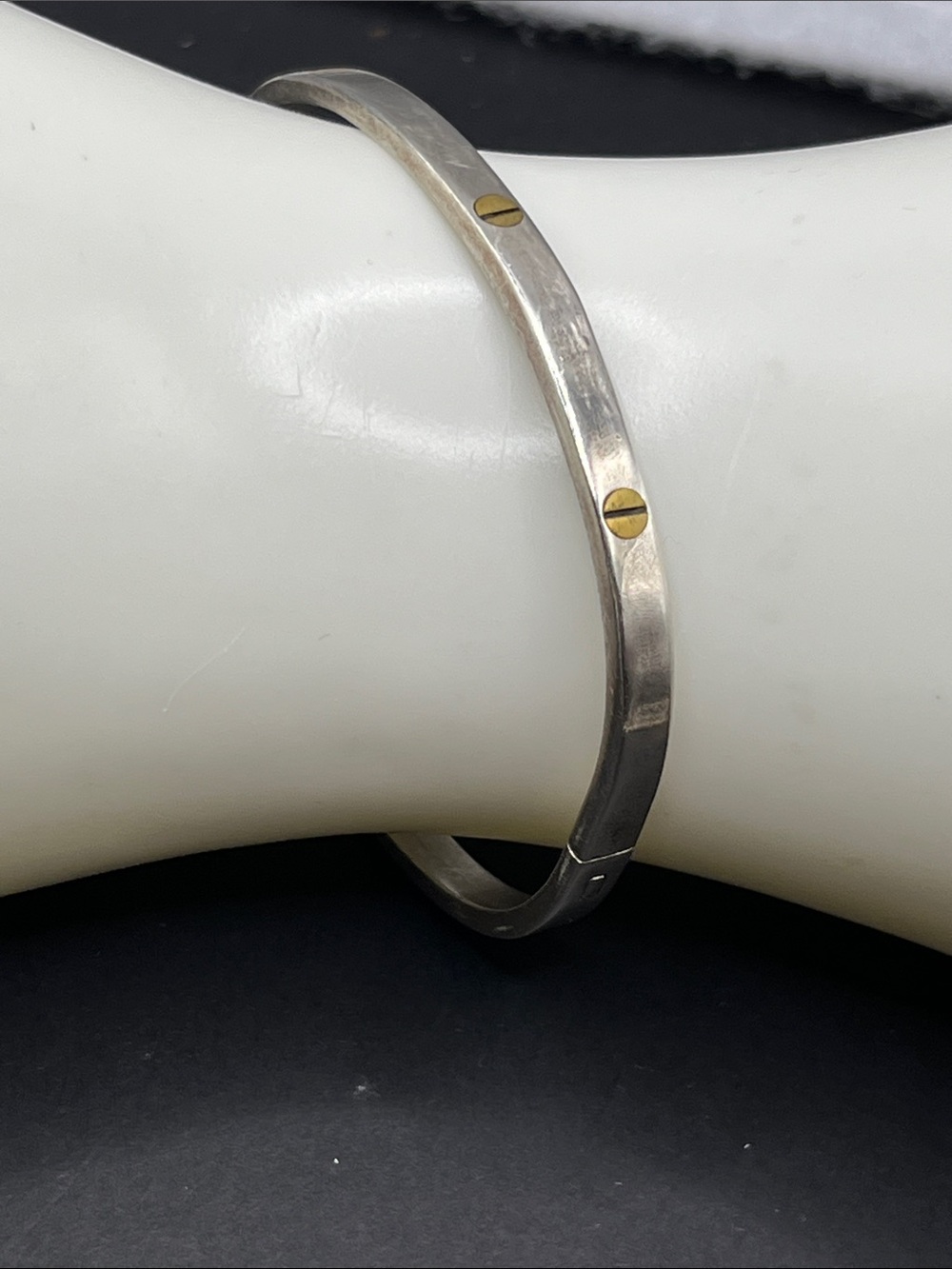 Oval hinged sterling silver cuff bracelet with small brass color rivets